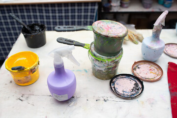 Serigraphy silk screen print process at clothes factory. Plastisol color paints at table.