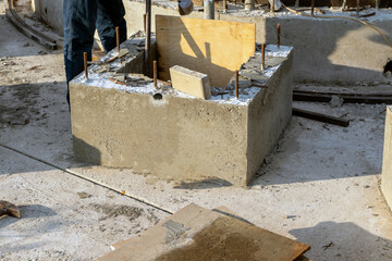 A worker removes wooden formwork after the concrete structure hardens at a construction site.