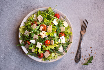 Fresh vegetable salad with tomatoes, arugola, parmesan cheese and other ingredients, healthy eating