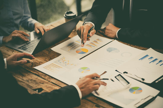 Group of business people meeting together Pointing to the graph assess business profits