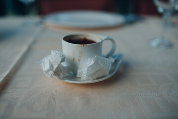 Table in cafe with empty coffee cup and napkins.