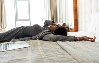 Tired African-American businesswoman are finally resting in the hotel room after all day discussing...