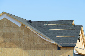 edge of roof shingles on top of the house, dark asphalt tiles on the roof