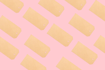 Etiquetas marrones de cartón sin expresion sobre un fondo rosa pastel liso y aislado. Vista superior y de cerca. Copy space