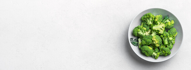 Broccoli sliced in a gray plate on a light background. Healthy food. Top view, place to copy