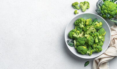 Obraz premium Fresh broccoli in a plate on a gray background with space to copy. Healthy, healthy food. Top view, horizontal