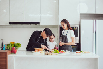Asian family cooking at home. Happy family cooks together in the kitchen home recreation and weekend meal prep.