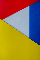Abstract paper is a colorful background, a creative design for pastel wallpaper. Yellow, white, red and blue colors. Clash of Russia and Ukraine, war. The symbol of intertwining and overlapping.