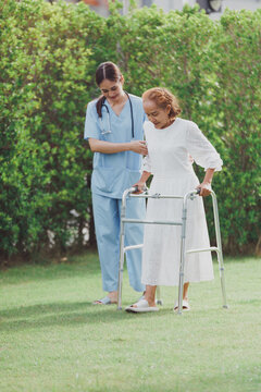 Asian young woman nurse at nursing home take care, patient and woman nurse  walk in the park, man caregiver helping patient, Happiness Asian family concepts