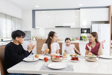 Happy Asian family dining at home. families enjoy together at home while having a meal at dining table.