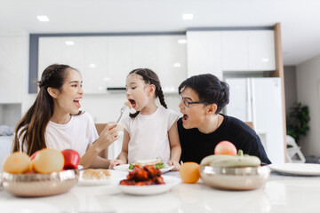 Asian family having meals together and showing thumbs up at home happily, Happy young parents are...