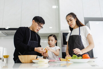 Asian family cooking at home. Happy family cooks together in the kitchen home recreation and weekend meal prep.