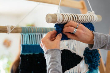Close up of woman's hands making macrame