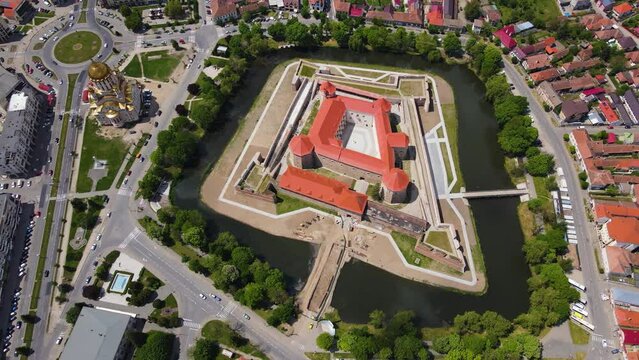 Aerial footage of the Citadel of Fagaras, in Brasov county, Romania. Video was shot from a drone with camera tilted downwards at a lower angle. Birds eye view over medieval fort.
