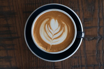 a cup of latte coffee on wood table.