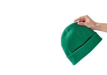 Green beanie hat in a girl's hand on a white background. Autumn headdress unisex. Copy space