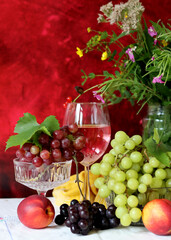 Wine and fruit on a table. Beautiful composition of juicy berries, grapes and rose wine. Harvest celebration. Textured background with copy space. 