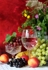 Wine and fruit on a table. Beautiful composition of juicy berries, grapes and rose wine. Harvest celebration. Textured background with copy space. 