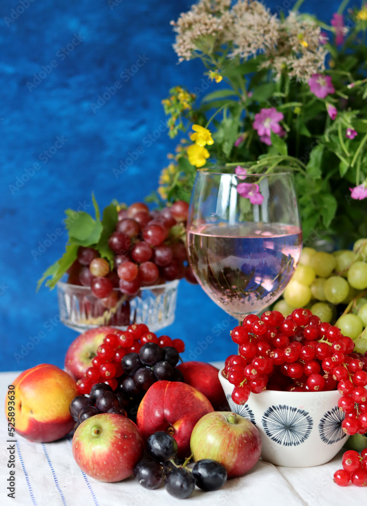 Poster Wine and fruit on a table. Beautiful composition of juicy berries, grapes and rose wine. Harvest celebration. Textured background with copy space. 