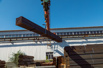 Gantry crane transporting stack of metal pipes
