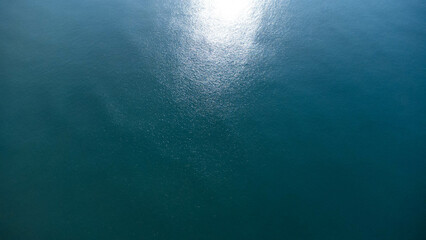 Luchtfoto van het gedreun van de zee. Achtergrondafbeelding van zeeoppervlak met zonlicht reflecterend op het wateroppervlak. blauwe zee achtergrond in tropische zee