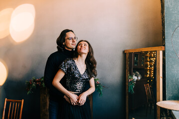 Happy young couple in Christmas hug at home indoors at home decorated with christmas decorations