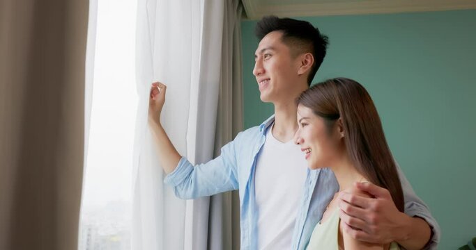 happy asian couple watching outside