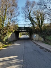 Puente de ferrocarril sobre una carretera rural en Baamonde, Galicia