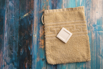 high angle view of a yellow washcloth with a piece of a white soap on a table