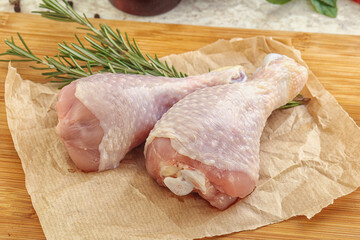 Raw chicken leg over board