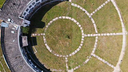 An abandoned building with a beautiful pattern of paths. The Assy-Turgen Observatory. The paths are laid out in the form of a telescope. Green grass grows, and purple bushes grow on the roof. Drone