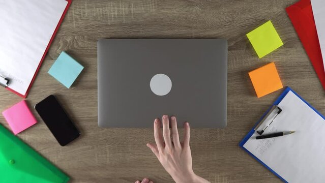 The freelancer is finishing the work at home. Modern workplace. Opening laptop.