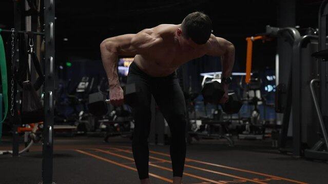 strong sportsman training in sport gym with dumbbell. sport sportsman with dumbbell in gym.