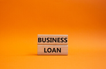 Business loan symbol. Concept words business loan on wooden blocks. Beautiful orange background. Business and business loan concept. Copy space.