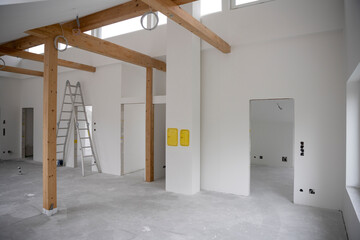 modern attic construction site freshly painted, the floor is still screed, walls are white