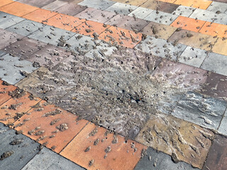 Traces on the pavement tile from the explosion of a mortar shell. War, Racism © Prodocdrone