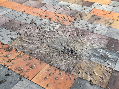 Traces on the pavement tile from the explosion of a mortar shell. War, Racism