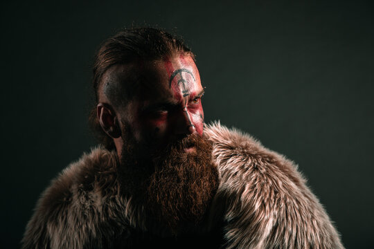 Stern and serious viking warrior with war paint waiting for battle