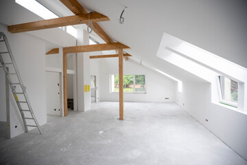 modern attic construction site freshly painted, the floor is still screed, walls are white