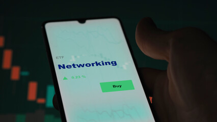 An investor's analyzing the  on screen. A phone shows the ETF's prices networking