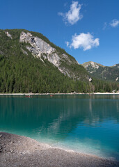 Lots of wooden boats in a picturesque, blue Braies lake.Logo di Braies Pragser Wildsee in Italy.  Alps. Dolomites mountains in South Tyrol Coniferous forest. Blue sky . Tourist place. High mountains.