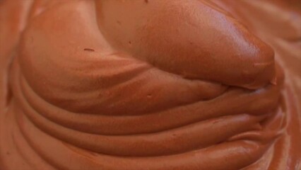 Making chocolate Mousse Cake , spreading smooth chocolate mousse on top of sponge cake