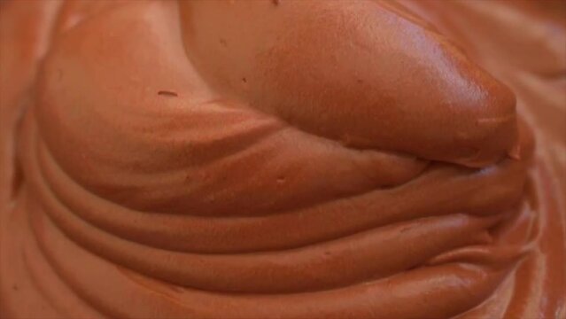 Making chocolate Mousse Cake , spreading smooth chocolate mousse on top of sponge cake