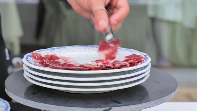 cutting slices of iberian ham in an elegant outdoor cocktail