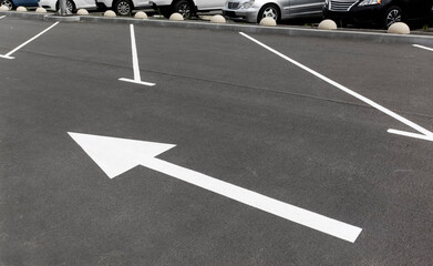 White arrow pointer on asphalt