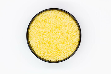 A plate of rice. Black bowl with grains of white rice on the white background. Healthy food. Raw white rice milled that has had husk, bran, germ removed. Isolated. Yellow grain. Top view. Close-up © sb2010