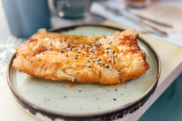 Authentic Greek Fried Cheese, Saganaki or Feta, tasty appetizer: crunchy on the outside with honey and sesame seeds