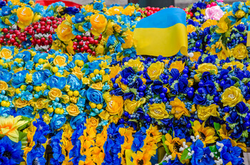 National flag of Ukraine and traditional ukrainian wreaths on souvenir market - obrazy, fototapety, plakaty