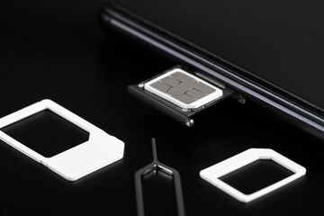 SIM card inserted into the sim card tray of a smartphone with pin needle tray remover