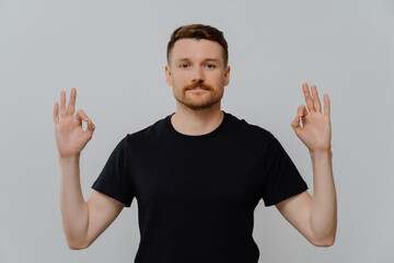 Young confident man showing okay gesture with both hands and showing his approval
